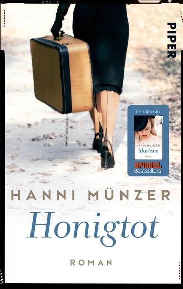Das Buchcover zeigt eine Frau in eleganter schwarzer Kleidung mit einem Koffer in der Hand, die auf einem herbstlichen Weg aus Laub geht. Der Titel „Honigtot“ von Hanni Münzer ist in eleganter Schrift in einem sanften Goldton platziert. Oben auf dem Cover steht der Verlag „Piper“ in schlichter schwarzer Schrift. Ein blauer Button mit „Der 1. Band des Marlene“ ist ebenfalls zu sehen, umgeben von weißem Text, der „SPOTLIGHT Bestsellers“ anzeigt. Die Atmosphäre wirkt nostalgisch und geheimnisvoll.