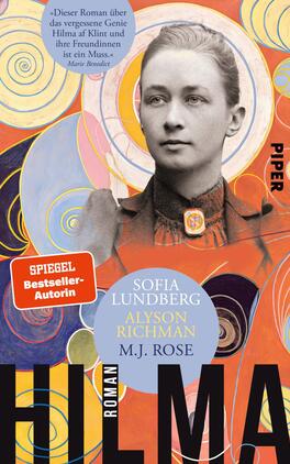 Das Buchcover zeigt ein Porträt einer Frau in historischer Kleidung, die nachdenklich in die Kamera blickt. Hinter ihr befinden sich spiralförmige, farbenfrohe Muster in Blau, Orange und Gelb, die eine kreative, lebendige Atmosphäre schaffen. Der Titel „HILMA“ ist in großen, schwarzen Buchstaben am unteren Rand platziert. Oben links befindet sich ein rotes Banner mit dem Text „SPIEGEL Bestseller-Autorin“. Die Autorennamen Sofia Lundberg, Alyson Richman und M.J. Rose sind zentral angeordnet.