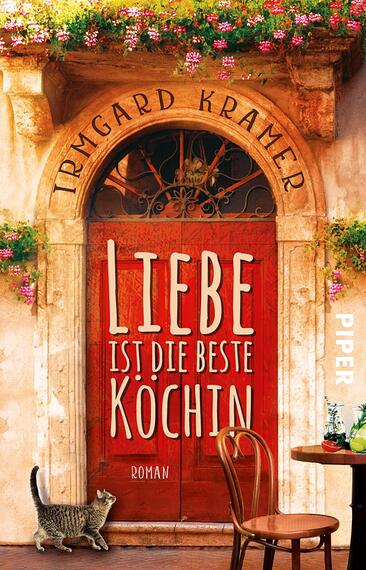 Das Buchcover zeigt eine warme, einladende Tür mit einem roten Anstrich, umrahmt von blühenden Pflanzen und einer geschwungenen Eisengitter. Der Titel „Liebe ist die beste Köchin“ steht in großen, weißen Buchstaben im Zentrum, während der Autorenname „Irmgard Kramer“ in einer verspielten Schrift oben platziert ist. Im unteren rechten Bereich befindet sich das Verlagslogo „PIPER“. Eine kleine Katze sitzt auf dem Boden vor einem Tisch, was eine gemütliche Atmosphäre vermittelt.