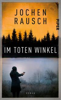 Das Buchcover zeigt eine dramatische Szenerie mit einem orangefarbenen Himmel über einer silhouetteartigen Waldlandschaft. Im unteren Bereich ist eine Person in schwarzer Kleidung abgebildet, die mit einer Hand eine Waffe hält und auf einen nebligen Hintergrund zielt. Der Titel „IM TOTEN WINKEL“ erscheint in markanter, weißer Schrift, während der Autor „Jochen Rausch“ in größeren, schwarzen Buchstaben am oberen Rand prangt. Die Gesamtatmosphäre vermittelt Spannung und Mystik. Das Verlagslogo ist in der oberen rechten Ecke platziert.