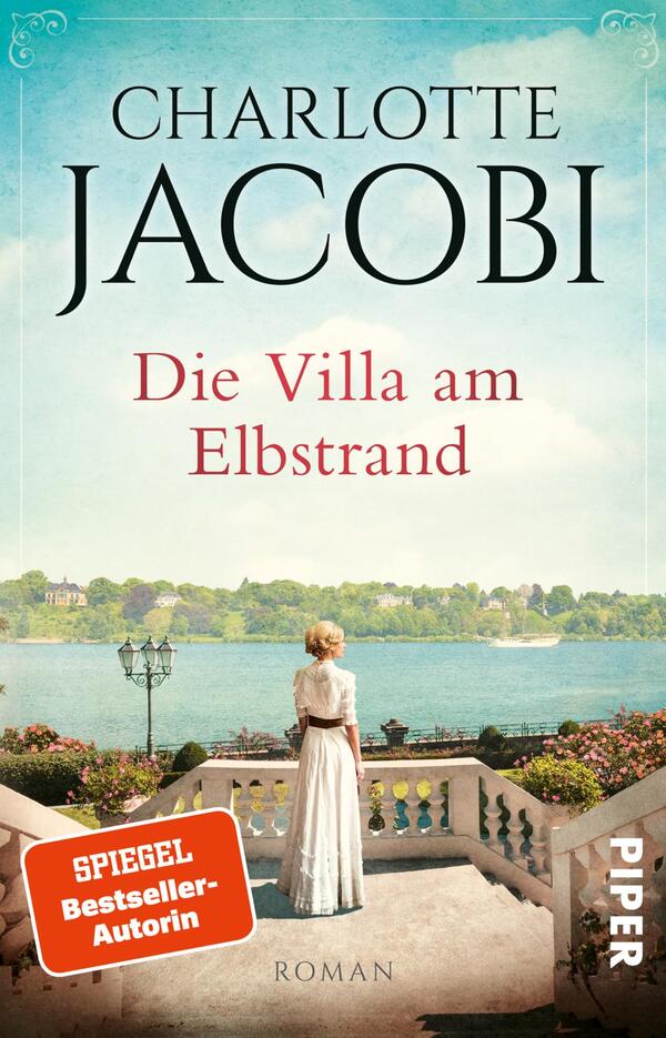 Das Buchcover zeigt eine nostalgische Szene mit einer Frau in einem weißen Kleid, die an einer eleganten Balustrade steht und den Blick auf den Elbstrom richtet. Die Farben sind sanft und hell, dominierend sind Blau- und Cremetöne, die eine harmonische Atmosphäre schaffen. Der Titel „Die Villa am Elbstrand“ ist in roter Schrift unter dem Namen der Autorin Charlotte Jacobi platziert, die in großen, klaren Buchstaben oben steht. Oben rechts ist der Hinweis „SPIEGEL Bestseller-Autorin“ in kleinerer Schrift zu sehen.