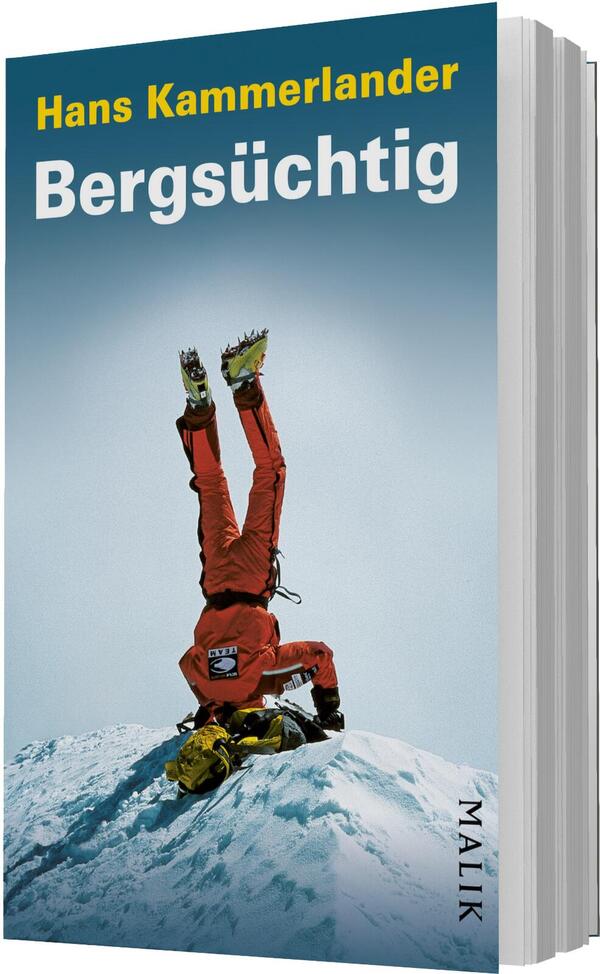 Das Buchcover zeigt einen verschneiten Gipfel vor einem blauen Himmel, darauf einen in roter Expeditionstracht gekleideten Bergsteiger, der kopfüber auf dem Kopf balanciert; gelbe Steigeisen und Helm sichtbar. Oben links der Autorenname Hans Kammerlander in gelber Schrift, darunter groß der Titel „Bergsüchtig“ in weißer, fetter, serifenloser Typografie. Die Bildwirkung ist kühl, luftig und risikoreich.