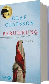 Das Buchcover zeigt einen sanften, hellblauen Hintergrund. Im Vordergrund hängt ein rotes Kleidungsstück an einer Schnur, das italienisch beige Farbe hat und teilweise faltig wirkt. Der Titel „BERÜHRUNG“ erscheint in großen, roten Buchstaben, während der Autorennamen „OLAF OLAFSSON“ in hellblauer Schrift darüber platziert ist. Am oberen Rand ist ein goldener Aufkleber mit der Aufschrift „10 Jahre berlin verlag“ zu sehen. Die gesamte Gestaltung vermittelt eine ruhige und nachdenkliche Atmosphäre.