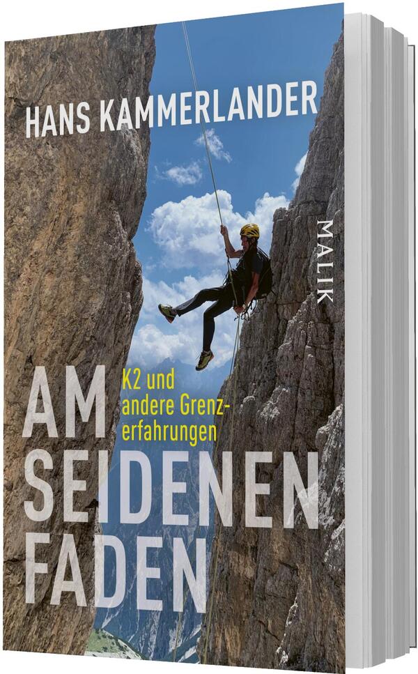 Das Buchcover zeigt einen Bergsteiger in schwarzer Kleidung und gelbem Helm, hängend an einem Seil zwischen zwei steilen, bräunlich-grauen Felswänden vor blauem Himmel mit weißen Wolken. Oben mittig steht der Autorenname „Hans Kammerlander“ in großen weißen Großbuchstaben; der Titel „Am seidenen Faden“ nimmt links unten den Raum in kräftiger weißer, serifenloser Schrift ein. Die gelbe Unterzeile „K2 und andere Grenzerfahrungen“ verstärkt die spannungsreiche, alpine Atmosphäre.