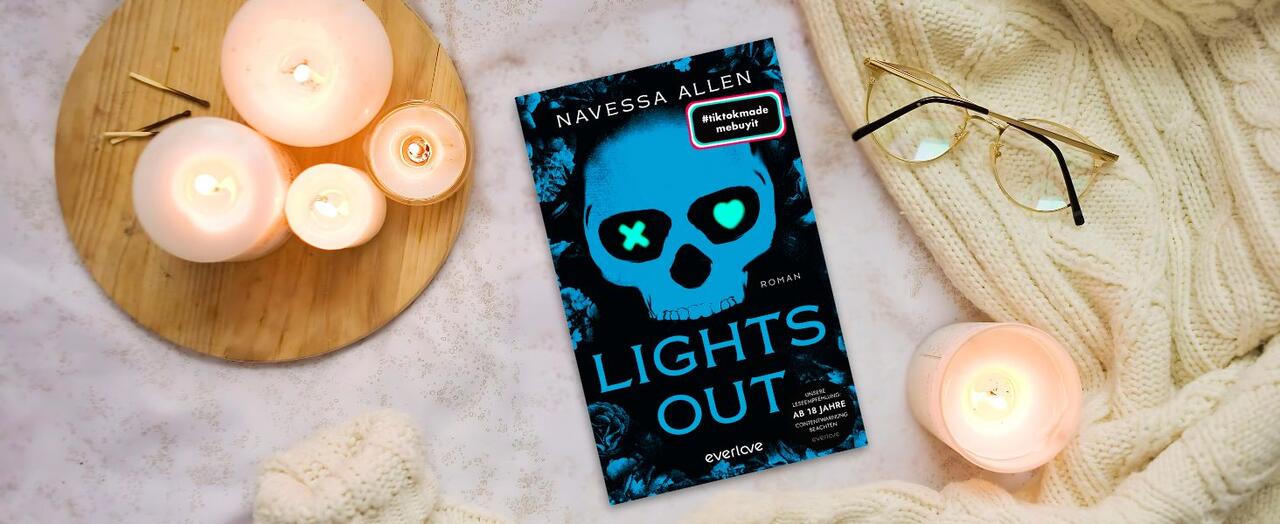 "Lights Out" von Navessa Allen liegt auf einer weißen, gestrickten Decke. Daneben stehen brennende Kerzen auf einem Holztablett, Streichhölzer und eine goldene Brille.