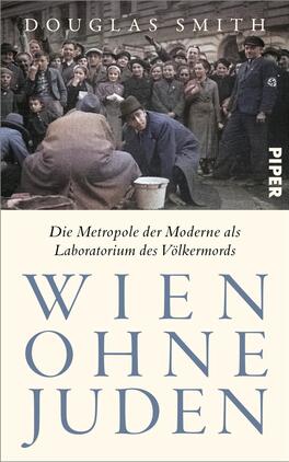 Das Buchcover zeigt ein historisches, bräunlich getöntes Foto oben mit einer dicht gedrängten Menschenmenge auf einer Straße und einem uniformierten Mann mit sichtbarem Ärmelabzeichen, die Stimmung ist bedrückend. Darunter eine cremefarbene Fläche mit dem kleinen Serif-Untertitel „Die Metropole der Moderne als Laboratorium des Völkermords“ und dem großen, blaugrauen, eleganten Serif-Großbuchstaben-Titel „WIEN OHNE JUDEN“. Autor oben: Douglas Smith.