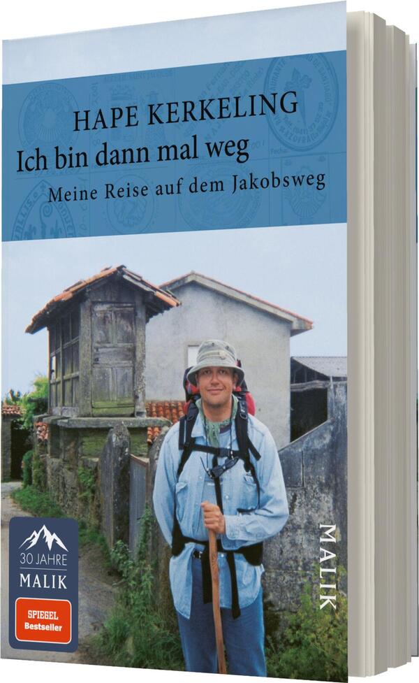 Das Buchcover zeigt einen lächelnden Mann in wandernder Pose, gekleidet in einer grauen Jacke und mit einem Rucksack. Im Hintergrund sind alte, rustikale Gebäude und eine grüne Landschaft zu sehen. Die obere Hälfte des Covers ist in einem sanften Blau gehalten, auf dem der Titel „Ich bin dann mal weg“ und der Autor „Hape Kerkeling“ in klarer, schwarzer Schrift platziert sind. Unter dem Titel steht die Unterzeile „Meine Reise auf dem Jakobsweg“ in kleinerer Schrift. Das Cover vermittelt eine Atmosphäre von Abenteuer und Entschlossenheit.