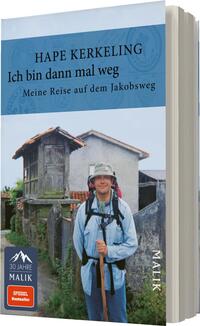 Das Buchcover zeigt einen lächelnden Mann in wandernder Pose, gekleidet in einer grauen Jacke und mit einem Rucksack. Im Hintergrund sind alte, rustikale Gebäude und eine grüne Landschaft zu sehen. Die obere Hälfte des Covers ist in einem sanften Blau gehalten, auf dem der Titel „Ich bin dann mal weg“ und der Autor „Hape Kerkeling“ in klarer, schwarzer Schrift platziert sind. Unter dem Titel steht die Unterzeile „Meine Reise auf dem Jakobsweg“ in kleinerer Schrift. Das Cover vermittelt eine Atmosphäre von Abenteuer und Entschlossenheit.