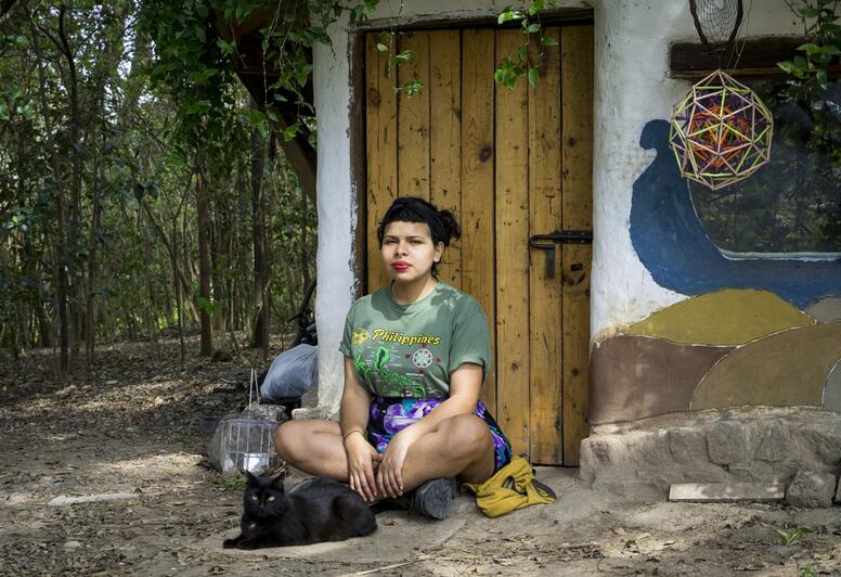 Junge Frau vor einem Häuschen, Gemeinschaft Velatropa