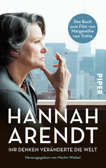 Das Buchcover zeigt ein Portrait einer nachdenklich wirkenden Frau mit grauen Haaren, die in einem modernen städtischen Umfeld sitzt. Im Hintergrund sind Wolkenkratzer zu sehen, die eine urbane Atmosphäre schaffen. Der Titel „HANNAH ARENDT“ erscheint in großen, weißen Buchstaben, gefolgt von „IHR DENKEN VERÄNDERTE DIE WELT“ in kleinerer Schrift. Oben rechts befindet sich ein blauer Kreis mit dem Text „Das Buch zum Film von Margarethe von Trotta“. Der Verlag ist mit „PIPER“ in der unteren rechten Ecke angegeben.