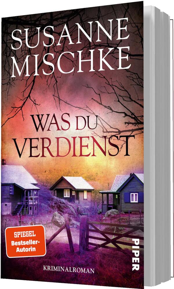 Das Buchcover zeigt den Namen der Autorin Susanne Mischke oben in großen weißen Serif-Versalien; mittig der Titel „WAS DU VERDIENST“ in betonten serifenhaften Großbuchstaben. Der Hintergrund zeigt violett-rosa-orangene Dämmerungsfarben, kahle Äste als dunkle Silhouetten und drei abgelegene Häuser hinter einem Holzzaun. Die Stimmung ist unheilvoll und spannungsgeladen. Ein orangefarbener Aufkleber trägt den Text „SPIEGEL Bestseller-Autorin“, unten steht klein „Kriminalroman“.