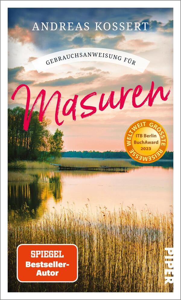 Das Buchcover zeigt eine malerische Landschaft mit einem ruhigen See, umgeben von einem Wald. Der Himmel ist in sanften Pastellfarben gehalten, die auf eine Dämmerung hindeuten. In der oberen Hälfte steht in klarer, schwarzer Schrift der Name des Autors „Andreas Kossert“. Darunter ist der Titel „Gebrauchsanweisung für Masuren“ in einer geschwungenen, leuchtend roten Schrift gesetzt. Ein gelbes Siegel mit der Aufschrift „ITB Berlin BuchAward 2023“ und die Angabe „SPIEGEL Bestseller-Autor“ ergänzen die Gestaltung.