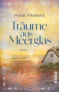 Das Buchcover zeigt eine sanfte Küstenlandschaft bei Sonnenuntergang. Im Vordergrund ist ein helles Strandhaus zu sehen, umgeben von goldenen Sanddünen und grasbewachsenen Flächen. Der Titel „Träume aus Meerglas“ ist in eleganter, geschwungener Schrift in Blau gehalten, wobei die Schriftzüge teilweise überlappend sind. Der Autorenname „Maia Franke“ steht in einer schmaleren Schrift darüber. Die Farbpalette umfasst warme Gelbtöne und sanfte Blautöne, die eine verträumte Atmosphäre erzeugen.