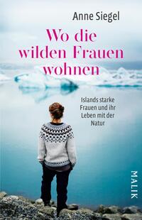 Das Buchcover zeigt eine weibliche Person von hinten, die an einem Küstenabschnitt steht und auf eine Eislandschaft blickt. Im Hintergrund sind Schwimmer von Eisschollen und eine sanfte, neblige Atmosphäre zu erkennen. Der Titel „Wo die wilden Frauen wohnen“ ist in großen, pinken Buchstaben platziert, während der Untertitel „Islands starke Frauen und ihr Leben mit der Natur“ in kleinerer, weißer Schrift direkt darunter steht. Der Name der Autorin, Anne Siegel, ist oben auf dem Cover abgedruckt.