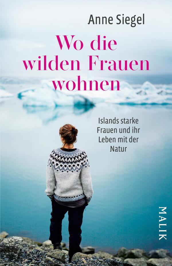 Das Buchcover zeigt eine weibliche Person von hinten, die an einem Küstenabschnitt steht und auf eine Eislandschaft blickt. Im Hintergrund sind Schwimmer von Eisschollen und eine sanfte, neblige Atmosphäre zu erkennen. Der Titel „Wo die wilden Frauen wohnen“ ist in großen, pinken Buchstaben platziert, während der Untertitel „Islands starke Frauen und ihr Leben mit der Natur“ in kleinerer, weißer Schrift direkt darunter steht. Der Name der Autorin, Anne Siegel, ist oben auf dem Cover abgedruckt.