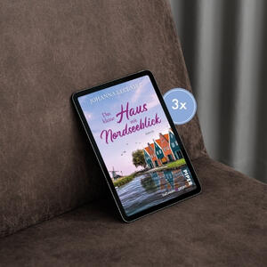Ein eReader, auf dem das Cover von „Das kleine Haus mit Nordseeblick“ zu sehen ist, liegt auf einer braunen Couch.