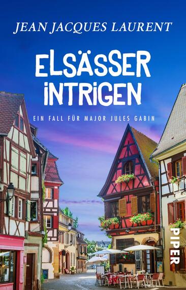 Das Buchcover zeigt eine malerische elsässische Straße mit traditionellen Fachwerkhäusern, die in warmen Rot- und Beigetönen gehalten sind. Der Himmel ist strahlend blau mit sanften Wolken, was eine einladende Atmosphäre schafft. Oben links steht der Name des Autors „Jean Jacques Laurent“ in weißer, eleganter Schrift. Der Titel „ELSAESSER INTRIGEN“ ist bold und in einer verspielten Schriftart dargestellt, was die Neugier des Lesers weckt. Darunter steht in kleinerer Schrift „Ein Fall für Major Jules Gabin“. Rechts befindet sich das Verlagslogo von PIPER.