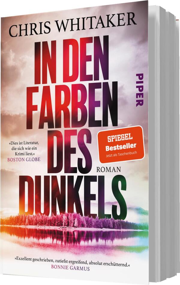 Das Buchcover zeigt einen farbenfrohen Himmel, der sich von einem kräftigen Lila zu sanften Rosa- und Gelbtönen wandelt. Im Vordergrund ist eine stilisierte Landschaft mit Bäumen und Wasser sichtbar. Der Titel „IN DEN FARBEN DES DUNKELS“ ist in großen, dunklen Buchstaben hervorgehoben, während der Autorennamen „CHRIS WHITAKER“ oben gut lesbar steht. Ein roter Aufkleber mit dem Text „SPIEGEL Bestseller“ ist ebenfalls abgebildet. Darunter steht in kleinerer Schrift „Roman“.