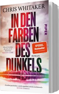 Das Buchcover zeigt einen farbenfrohen Himmel, der sich von einem kräftigen Lila zu sanften Rosa- und Gelbtönen wandelt. Im Vordergrund ist eine stilisierte Landschaft mit Bäumen und Wasser sichtbar. Der Titel „IN DEN FARBEN DES DUNKELS“ ist in großen, dunklen Buchstaben hervorgehoben, während der Autorennamen „CHRIS WHITAKER“ oben gut lesbar steht. Ein roter Aufkleber mit dem Text „SPIEGEL Bestseller“ ist ebenfalls abgebildet. Darunter steht in kleinerer Schrift „Roman“.