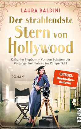 Das Buchcover zeigt eine Frau in einem stylischen blauen Outfit, die selbstbewusst vor einer Kamera steht. Im Hintergrund sind Filmrequisiten und ein Studio sichtbar, was die Hollywood-Atmosphäre unterstreicht. Der Titel „Der strahlendste Stern von Hollywood“ ist prominent in goldenen Buchstaben platziert. Der Untertitel nennt „Katharine Hepburn – Vor den Schatten der Vergangenheit floh sie ins Rampenlicht“. Zudem ist das Label „SPIEGEL Bestseller-Autorin“ in Rot hervorgehoben.