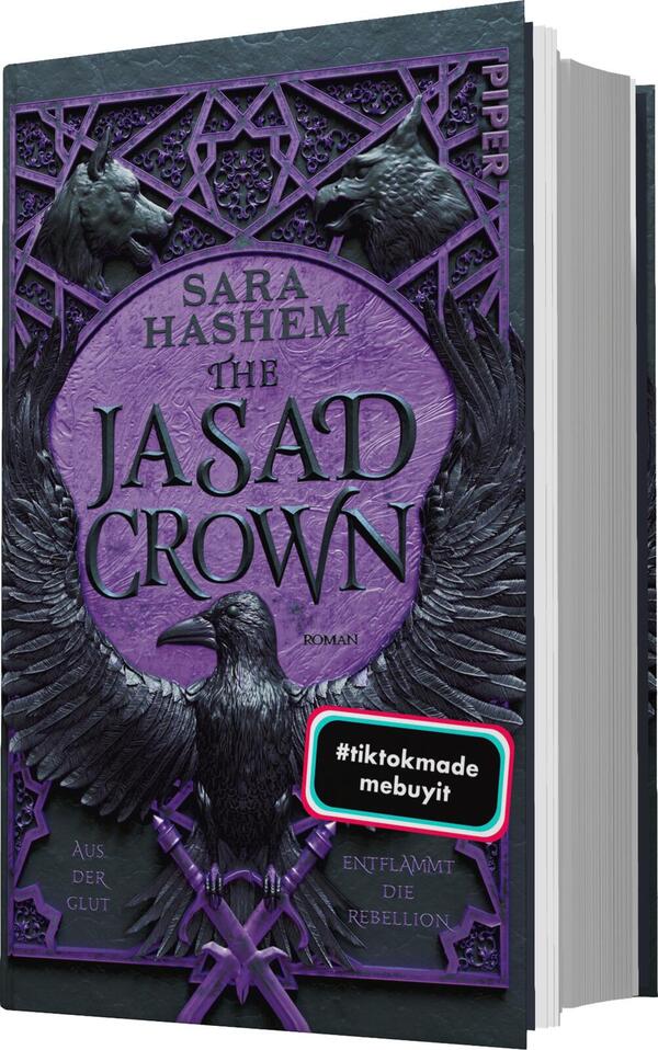 Das Buchcover zeigt einen dominanten, violetten Farbton, der eine mystische Atmosphäre vermittelt. Im oberen Bereich steht der Name der Autorin, „Sara Hashem“, in eleganter Schrift, gefolgt vom Titel „THE JASAD CROWN“, der in großen, weißen Buchstaben hervorsticht. Unterhalb des Titels sind stilisierte Flügel und eine Eule abgebildet, die das zentrale Motiv bilden. Ein blauer Button mit der Aufschrift „Vorläufiges Cover“ befindet sich unten auf dem Cover, zusätzlich wird „Entfacht die Rebellion“ in kleinerer Schrift angezeigt.