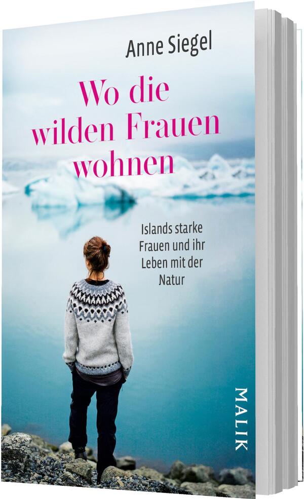 Das Buchcover zeigt eine Frau von hinten in einem isländischen Strickpullover, die auf einem felsigen Ufer zu einem kalten, blau-weißen Fjord mit treibenden Eisbergen blickt. Oben steht die Autorin „Anne Siegel“, der Titel „Wo die wilden Frauen wohnen“ erscheint groß in kräftigem Magenta in serifenbetonter Schrift; der Untertitel „Islands starke Frauen und ihr Leben mit der Natur“ ist klein und schwarz in sachlicher Grotesk. Atmosphäre: ruhig, klar und kühl.