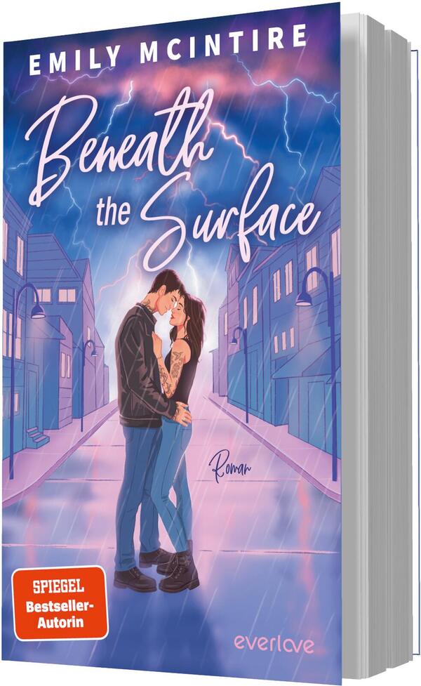 Das Buchcover zeigt ein Paar in inniger Umarmung im Bildmittelpunkt auf einer leeren, perspektivisch geführten Straße zwischen stilisierten Häusern. Der Himmel leuchtet in Violett-, Blau- und Rosa-Tönen mit sichtbaren Blitzen. Titel „Beneath the Surface“ ist groß in weißer, handschriftlicher Schrift gesetzt, der Autorenname EMILY MCINTIRE steht oben in breiter Großschrift. Ein orangener Button trägt den Text „SPIEGEL Bestseller-Autorin“. Atmosphäre: romantisch und elektrisierend.