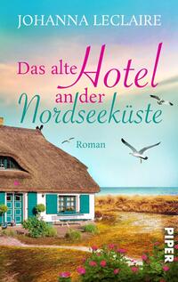 Das Buchcover zeigt ein malerisches, reetgedecktes Haus an der Nordseeküste, umgeben von sanften Wiesen und einem strahlend blauen Himmel. In der oberen Hälfte steht der Titel „Das alte Hotel“ in verspielter, pinker Schrift, während „an der Nordseeküste“ in eleganter, heller Schrift darunter erscheint. Der Autorinnenname „Johanna Leclaire“ ist prominent in weißer Schrift oben angebracht. Möwen sind im Flug zu sehen, was die maritime Atmosphäre unterstreicht. Der Hinweis „Roman“ ist in einer schlichten Schriftart am unteren Rand platziert.