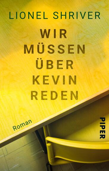 Das Buchcover zeigt eine schlichte, hellgelbe Tischoberfläche, die von einer leuchtend gelben Stuhllehne ergänzt wird. In der Mitte sind die großen, kräftigen Worte „WIR MÜSSEN ÜBER KEVIN REDEN“ in dunkelbrauner Schrift angeordnet. Der Name der Autorin, Lionel Shriver, steht oben in grünem Schriftzug, während das Wort „Roman“ in kleinerer Schriftgröße ebenfalls in dunkelbraun rechts unten platziert ist. Die Gesamtatmosphäre vermittelt einen klaren, direkten Ansatz.