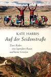 Das Buchcover zeigt zwei Radfahrerinnen in roten Jacken, die auf einer Gebirgslandschaft stehen. Im Hintergrund erstrecken sich weite, sanfte Hügel unter einem klaren Himmel. Der Titel „Auf der Seidenstraße“ ist in eleganter, schwarzer Schrift platziert, während der Untertitel „Zwei Räder, eine legendäre Route und keine Grenzen“ in kleinerer Schrift darunter steht. Der Autorenname, Kate Harris, steht prominent darüber. Die warmen Farben vermitteln ein Gefühl von Abenteuer und Freiheit.