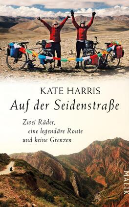 Das Buchcover zeigt zwei Radfahrerinnen in roten Jacken, die auf einer Gebirgslandschaft stehen. Im Hintergrund erstrecken sich weite, sanfte Hügel unter einem klaren Himmel. Der Titel „Auf der Seidenstraße“ ist in eleganter, schwarzer Schrift platziert, während der Untertitel „Zwei Räder, eine legendäre Route und keine Grenzen“ in kleinerer Schrift darunter steht. Der Autorenname, Kate Harris, steht prominent darüber. Die warmen Farben vermitteln ein Gefühl von Abenteuer und Freiheit.