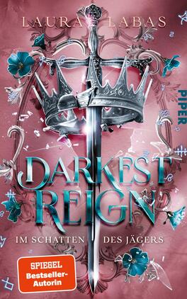Das Buchcover zeigt einen zentralen, schimmernden Silberstecher mit einem aufgesetzten krönenden Element. Rund um das Schwert sind floral gestaltete, blaue Elemente und leuchtende Akzente in Pink sowie im Hintergrund weist eine pastellfarbene Rosa-Tongebung auf. Der Titel „DARKEST REIGN“ ist in großen, kräftigen, türkisfarbenen Buchstaben platziert, während der Untertitel „IM SCHATTEN DES JÄGERS“ in kleinerer Schrift erscheint. Der Name der Autorin, Laura Labas, ist oben in eleganten Buchstaben zu sehen.