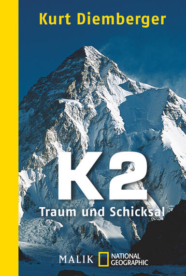 Das Buchcover zeigt eine beeindruckende Berglandschaft mit dem K2 im Vordergrund, dessen schneebedeckte Gipfel kraftvoll und majestätisch wirken. Der Hintergrund ist in kühlen Blautönen gehalten, die die Erhabenheit des Berges unterstreichen. Im oberen Bereich steht der Name des Autors „Kurt Diemberger“ in weißer Schrift. Zentral ist der Titel „K2“ in großen, weißen Buchstaben, darunter steht der Untertitel „Traum und Schicksal“ in kleinerer Schrift. Der Buchrücken ist in einem kräftigen Gelb gestaltet, was einen starken Kontrast zur Bildkomposition bildet.