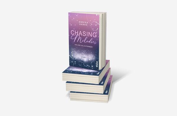 Bücherstapel des Buches „Chasing Melodies – Wir zwei im Lichtermeer“
