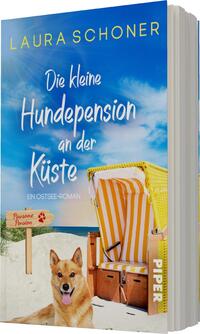 Das Buchcover zeigt einen entspannten Strand mit einem blauen Himmel, der leicht bewölkt ist. Im Vordergrund sitzt ein brauner Hund mit hellen Akzenten auf dem Sand. Auf der linken Seite steht ein typischer Strandkorb in Gelb und Weiß. Der Titel „Die kleine Hundepension an der Küste“ ist in geschwungener, weißer Schrift gehalten und hebt sich vom Hintergrund ab. Darunter steht „Ein Ostsee-Roman“ in schlichterer Schrift. Der Name der Autorin, „Laura Schoner“, ist oben in gelber Schrift platziert.