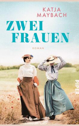 Das Buchcover zeigt zwei Frauen in historischer Kleidung, die nebeneinander auf einem blühenden Feld stehen. Die linke Frau trägt ein schlichtes, helles Oberteil und einen langen, roten Rock, während die rechte Frau in einem blauen Outfit und einem weitreichenden Hut zu sehen ist. Der Titel „Zwei Frauen“ steht in großen, türkisfarbenen Buchstaben mittig auf dem Cover, während darunter das Wort „Roman“ in kleinerer Schrift positioniert ist. Der Name der Autorin, Katja Maybach, ist oben in einer eleganten Schriftart platziert.