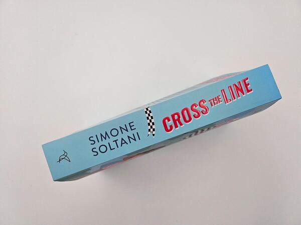 Außenansicht des Buches „Cross the Line – Auf der Rennstrecke kämpft er um den Sieg, im Leben um ihr Herz“