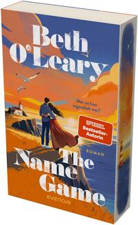 Das Buchcover zeigt ein Paar, eng umschlungen auf einer Klippenkante im Sonnenuntergang, Blick aufs Meer mit Leuchtturm links; warme Orange‑ und Blautöne dominieren, Möwen fliegen am Himmel. Titel „The Name Game“ groß in weißer Serifenschrift, oben Autorin „Beth O’Leary“ ebenfalls weiß; gelber Untertitel „Wer ist hier eigentlich wer?“. Roter Aufkleber „SPIEGEL Bestseller‑Autorin“. Atmosphäre: romantisch und leicht nostalgisch.