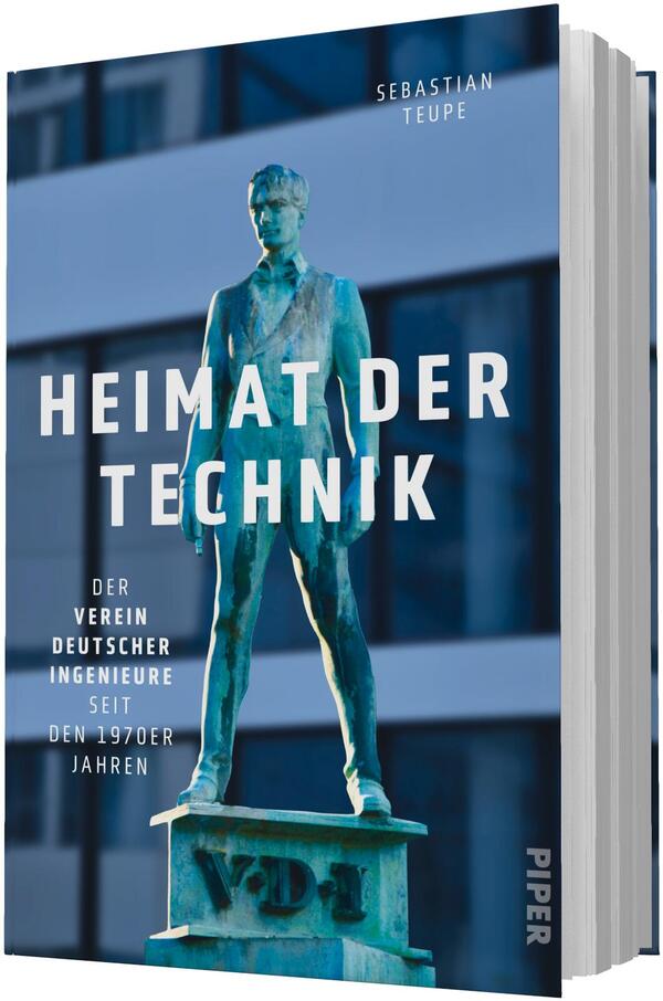 Das Buchcover zeigt eine grünpatinierte Bronzestatue eines stehenden Mannes auf einem Sockel mit der Inschrift VDI vor einem unscharf dargestellten, horizontal gegliederten Bürogebäude. Dominierende Farben sind Blau- und Grüntöne. Großflächiger weißer, fetter Grotesksatz in Versalien trägt den Titel „HEIMAT DER TECHNIK“. Oben rechts steht in kleiner weißer Groteskschrift der Autorenname Sebastian Teupe; links unten die kleine Unterzeile mit Vereinsangaben. Nüchterne, technische Atmosphäre.
