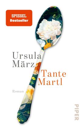 Tante Martl Das Buchcover zeigt einen großen Löffel mit floralem Muster in lebendigen Farben, der zentrale Element des Designs ist. Auf der linken Seite steht der Name der Autorin „Ursula März“ in eleganter, grauer Schrift, während der Titel „Tante Martl“ in auffälliger, oranger Schrift leicht schräg platziert ist. Unter dem Titel steht das Wort „Roman“ in kleinerer Schrift. Oben links ist ein rechteckiger, roter Hinweis auf einen „SPIEGEL Bestseller“ zu sehen.