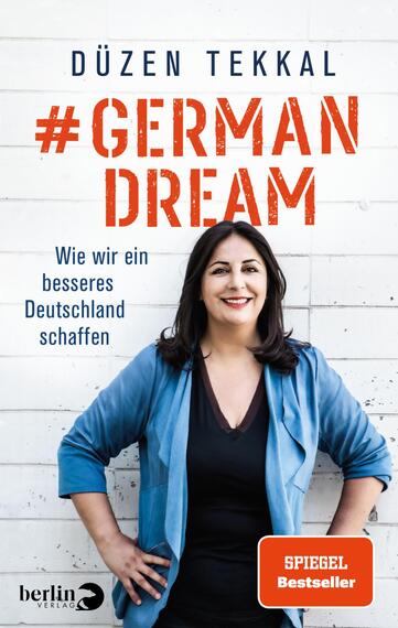 Das Buchcover zeigt eine lächelnde Frau mit langen, dunklen Haaren, die einen hellblauen Blazer über einem dunklen Oberteil trägt. Der Hintergrund ist in einem hellen Ton gehalten. In großen, kräftigen Buchstaben steht der Titel „#GERMAN DREAM“ in rot, während der Untertitel „Wie wir ein besseres Deutschland schaffen“ in kleinerer Schrift in schwarz erscheint. Unten rechts befindet sich ein Button mit dem Text „SPIEGEL Bestseller“.