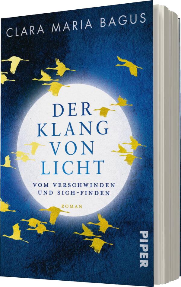 Das Buchcover zeigt einen tiefblauen Hintergrund mit einer großen, leuchtend weißen Kreisscheibe, die den Titel „DER KLANG VON LICHT“ umgibt. Der Titel ist in einer eleganten, kräftigen Schrift in Blau gehalten, darüber steht der Name der Autorin, „CLARA MARIA BAGUS“, in einer schlichten weißen Schrift. Gelbe Silhouetten von fliegenden Vögeln umrahmen die Kreisscheibe und erzeugen eine fühlbare Dynamik. Darunter ist der Untertitel „VOM VERSCHWINDET UND SICH-FINDEN“ in kleinerer Schrift positioniert, und am unteren Rand ist das Verlagslogo „PIPER“ platziert.