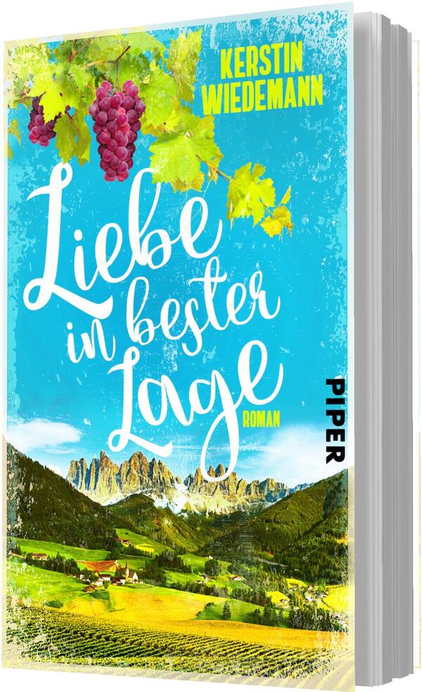 Das Buchcover zeigt eine idyllische Landschaft mit sanften Hügeln und Weinreben, die in leuchtendem Grün und Gelb gehalten sind. Im Hintergrund erheben sich markante Berge unter einem strahlend blauen Himmel. Der Titel „Liebe in bester Lage“ ist in geschwungener, weißer Schrift prominent platziert. Oberhalb des Titels steht der Autorenname „Kerstin Wiedemann“. Die Atmosphäre vermittelt eine positive, einladende Stimmung und lässt auf eine romantische Geschichte schließen.