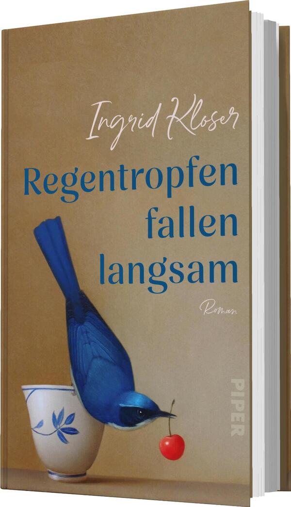 Das Buchcover zeigt einen blauen Vogel, der an einer roten Kirsche nascht, während er sich über eine weiße Tasse mit blauer Verzierung lehnt. Der Hintergrund ist in sanften Erdtönen gehalten, die eine ruhige Atmosphäre vermitteln. Der Titel „Regentropfen fallen langsam“ ist in eleganter blauer Schrift gedrückt, während der Autorenname „Ingrid Kloser“ in geschwungener, weißer Schrift darüber steht. Unter dem Titel ist der Vermerk „Roman“ zu finden.