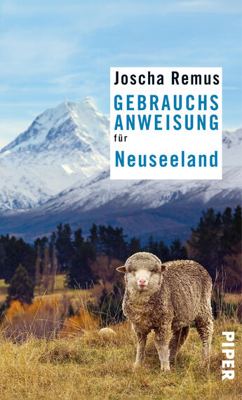 Das Buchcover zeigt eine malerische Landschaft mit schneebedeckten Bergen im Hintergrund und einer grünen Wiese im Vordergrund. Auf der Wiese steht ein Schaf, das den Betrachter anblickt. Die Farbpalette umfasst sanfte Grüntöne und ein strahlendes Blau des Himmels. Der Titel „GEBRAUCHSANWEISUNG für Neuseeland“ ist in großer, weißer Schrift auf blauem Hintergrund platziert, während der Name des Autors, Joscha Remus, darüber in schwarzer Schrift erscheint. Das Cover vermittelt eine einladende, natürliche Atmosphäre.