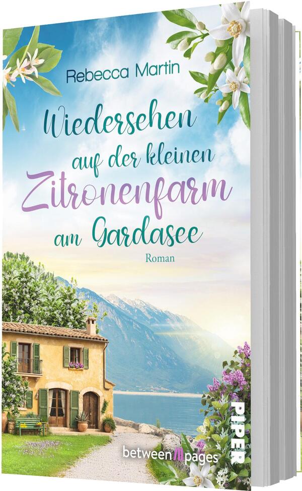 Das Buchcover zeigt eine sonnige, idyllische Szene am Gardasee mit einem warmgelben Landhaus am Ufer, einem schmalen Weg und blühenden Sträuchern. Im Hintergrund ragen blaue Berge unter hellem Himmel auf. Zitronenblüten und grüne Blätter rahmen das Motiv. Der Titel ist in verspielter, teilkursiver Typografie gesetzt, teils Türkis, Lila und Grün; Autorin Rebecca Martin ist namentlich genannt.