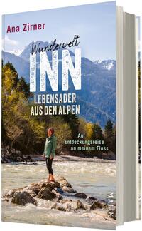 Das Buchcover zeigt eine Frau in grüner Jacke und dunkler Hose, stehend auf einem Felsen im flachen, schnell fließenden Gebirgsfluss Inn, umgeben von herbstlich gefärbten Bäumen und im Hintergrund schneebedeckte Alpenberge unter blauem Himmel. Oben links steht der Autorenname „Ana Zirner“ in roter Schrift; Titel groß in weißer, strukturierter Kapitälchen-Schrift: „Wunderwelt INN“, darunter in Beige „Lebensader aus den Alpen“ und kleiner: „Auf Entdeckungsreise an meinem Fluss“.