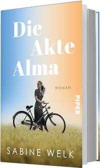Das Buchcover zeigt einen sanften Farbverlauf von Blau links zu Orange rechts, darüber groß in weißer Serifenschrift der Titel „Die Akte Alma“, darunter klein der Schriftzug „Roman“. Im Vordergrund steht eine Frau in dunklem, zeitlosem Kleid neben einem schwarzen Fahrrad in hohem Gras, sie blickt nach rechts. Unten als Autorenname erscheint Sabine Welk. Stimmung: nostalgisch, ruhig und leicht melancholisch.
