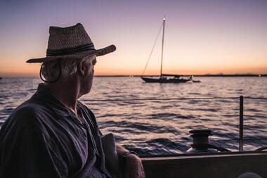 Marc Bielefelf auf dem Segelboot bei Sonnenuntergang