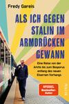 Das Buchcover zeigt einen bärtigen Mann in einem blauen Anzug, der an einer Bahnstation steht. Er blickt nachdenklich in die Ferne. Im Hintergrund verläuft ein Zug, und der Himmel ist in sanften Farben mit gelb, orange, grün und blau abgebildet, die eine dynamische Atmosphäre schaffen. Der Titel „ALS ICH GEGEN STALIN IM ARMDRÜCKEN GEWANN“ steht in großen, fetten weißen Buchstaben, während der Untertitel „Eine Reise von der Arktis bis zum Bosporus entlang des neuen Eisernen Vorhangs“ in etwas kleinerer Schrift darunter platziert ist.
